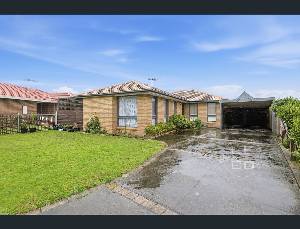 Front view of the home with lawn, curved driveway and covered carport